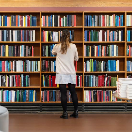 En person kigger på bøger på biblioteket. Fotokreditering: Christopher Egeberg for Centralbiblioteket.
